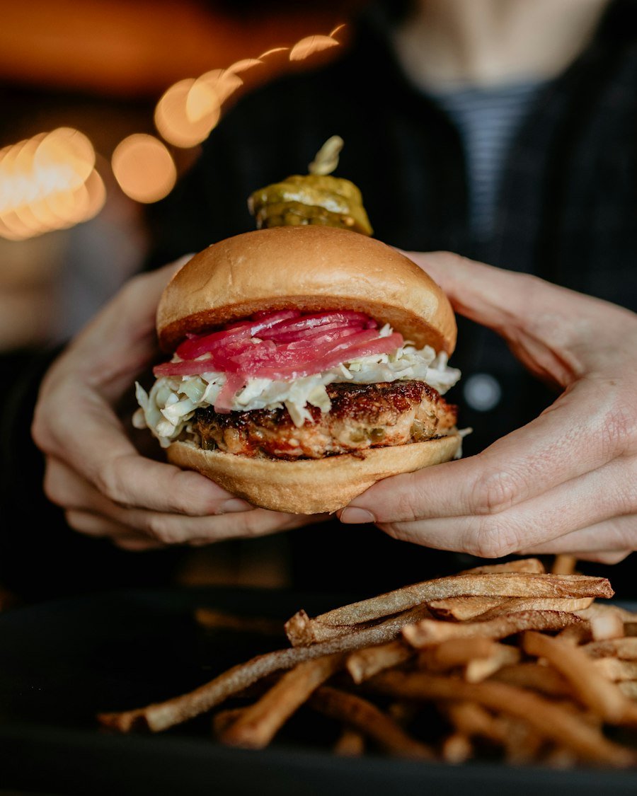Persona sujetando una hamburguesa con las dos manos
