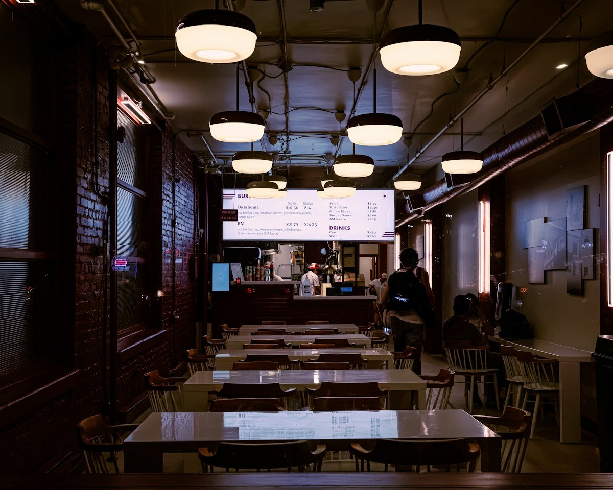 Interior de un restaurante con luz tenue y lámparas colgantes