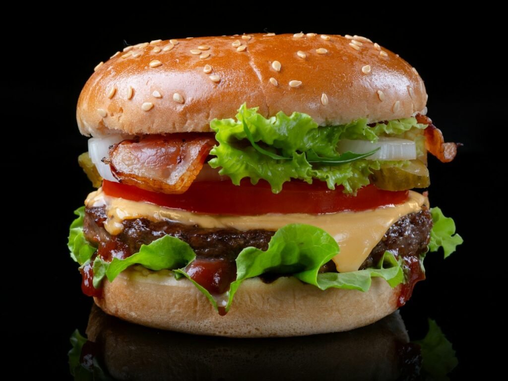 Hamburguesa con lechuga y tomate sobre fondo oscuro